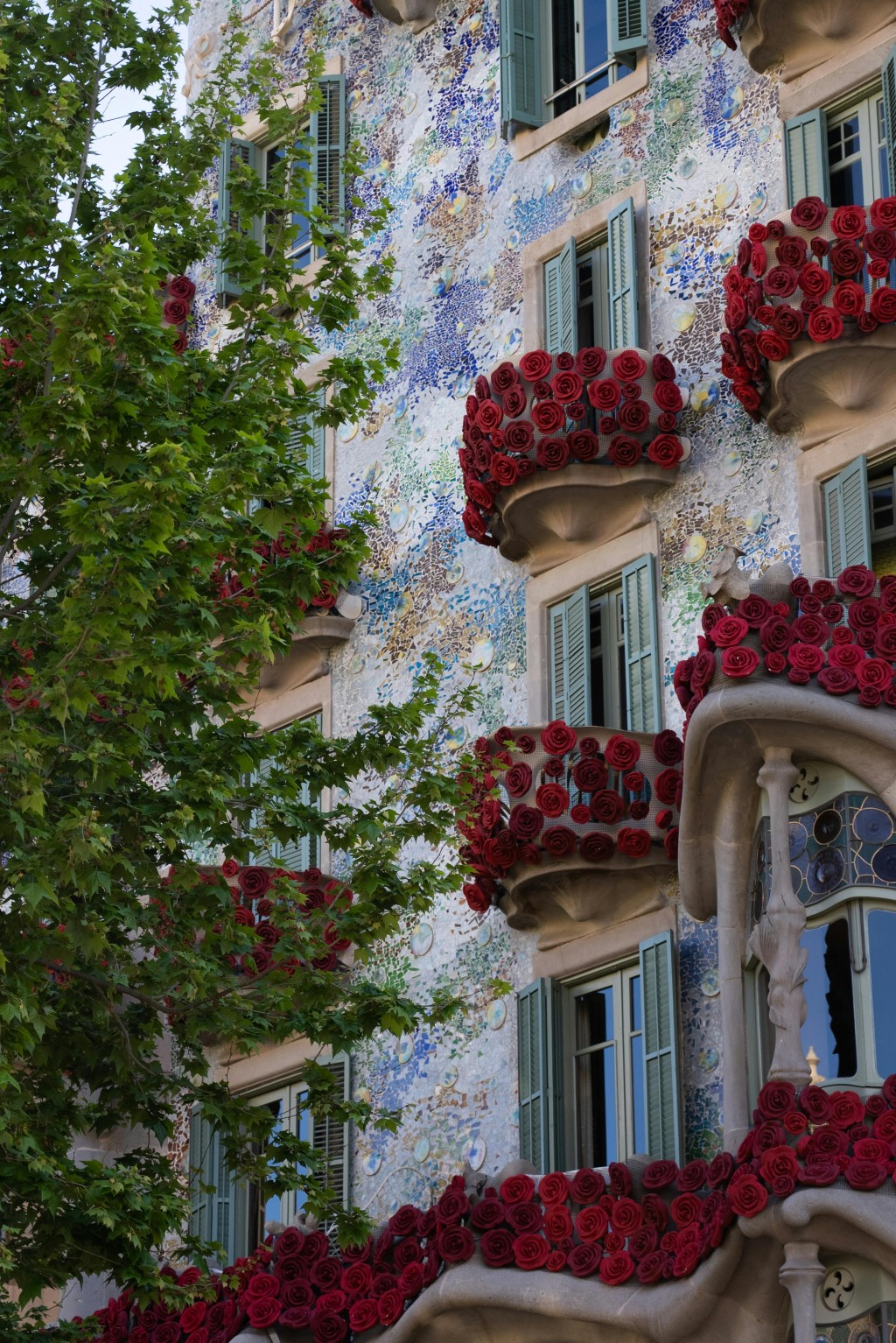 Detailed view of Gaudí's Casa Batlló facade adorned with hundreds of red roses on its balconies for the Sant Jordi festival in Barcelona.