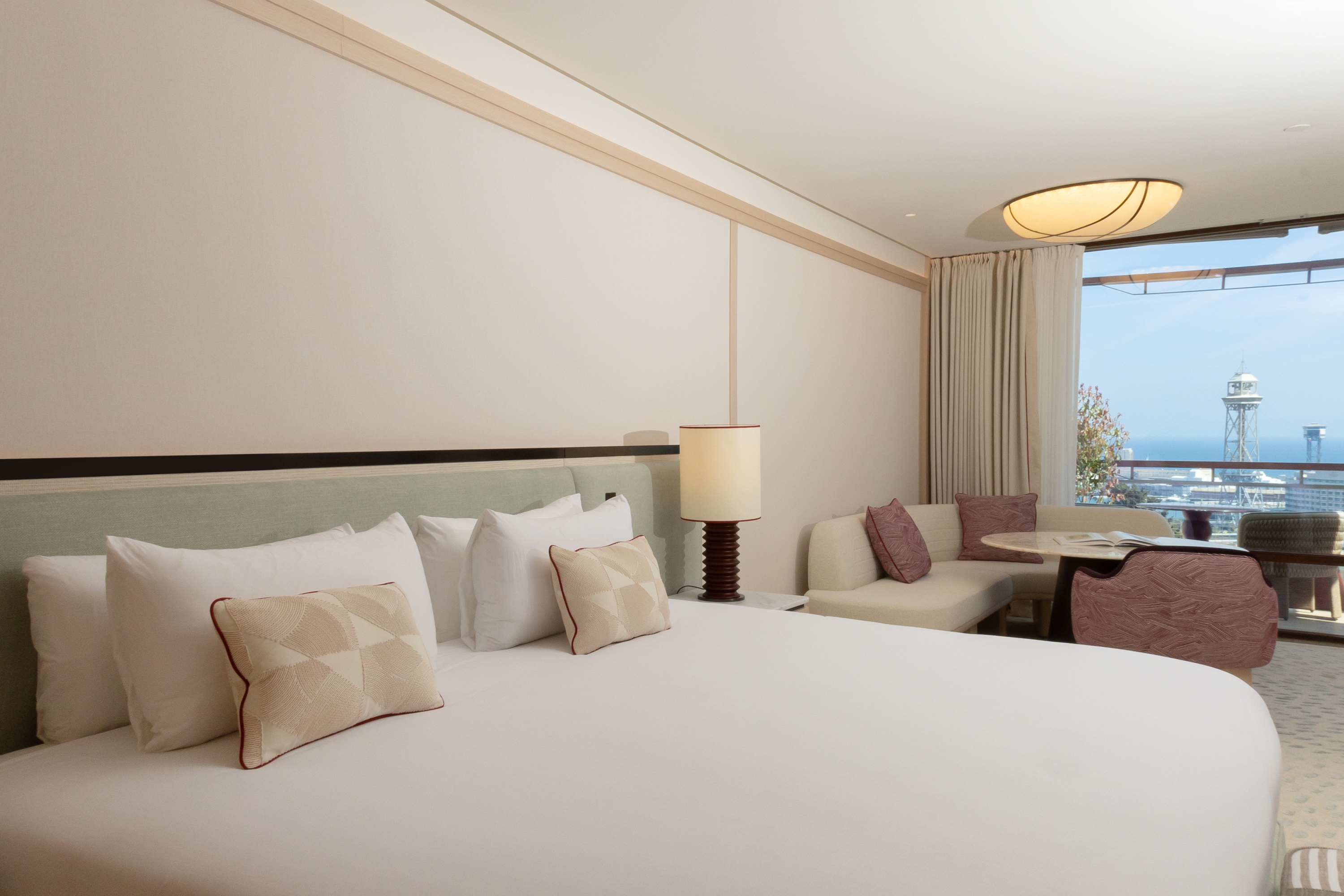 Cama King size en la Junior Suite con lencería de alta calidad y ambiente acogedor.