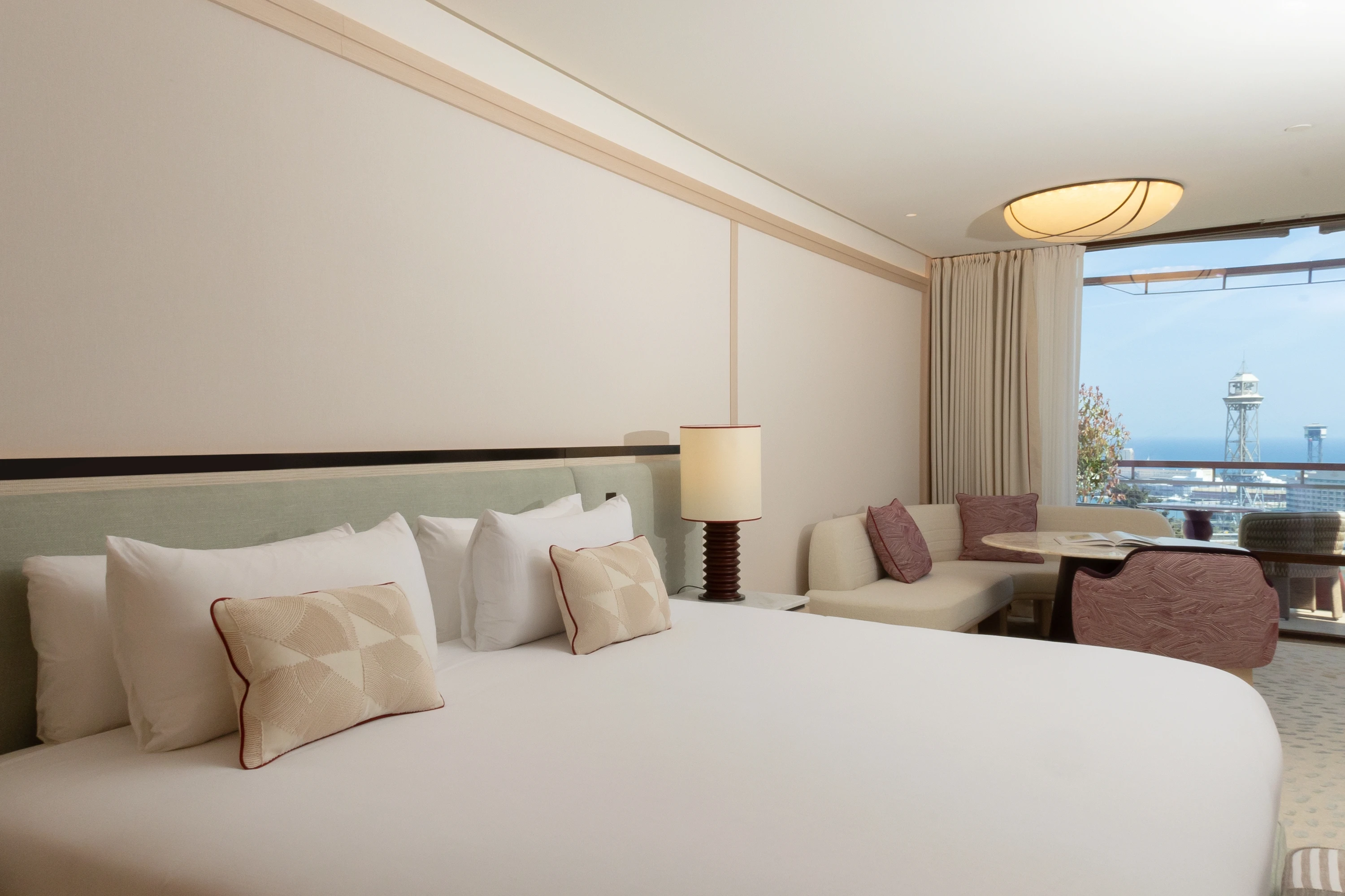 Cama King size en la Junior Suite con lencería de alta calidad y ambiente acogedor.